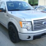 Before and after photographs of a damaged Ford pickup truck that was repaired by Elite Paint & Body Shop in West Palm Beach, Florida.
